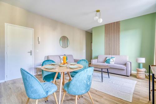 un salon avec une table, des chaises et un canapé dans l'établissement Appartement proche Olympiades, à Ivry-sur-Seine