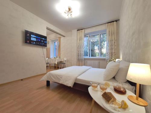 um quarto com uma cama e uma mesa com comida em Один каштан Мережа Alex Apartments Безконтактне заселення 24-7 em Poltava
