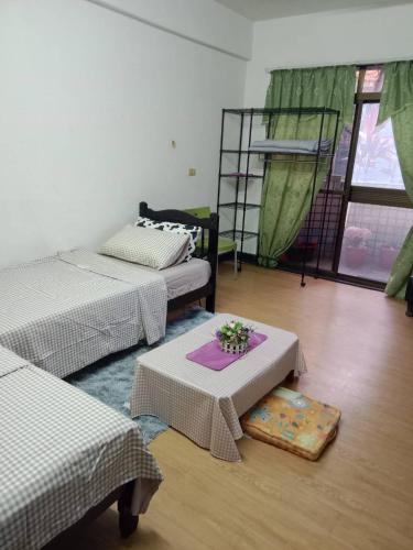 una habitación con 2 camas y una mesa con flores. en 鳳梨之家, en Lung-yen-chai