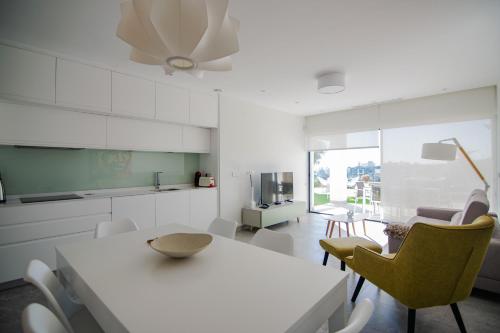 オリフエラ・コスタにあるResidencial Cabo Azulの白いキッチン(白いテーブルと椅子付)