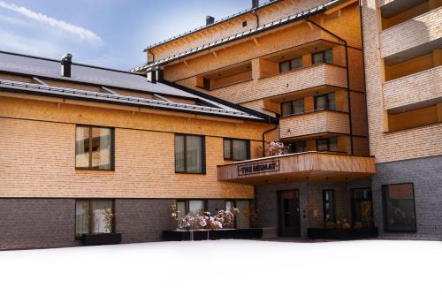 a large brick building with a balcony at Heimat 1495m Appartement TYP 6 in Schröcken