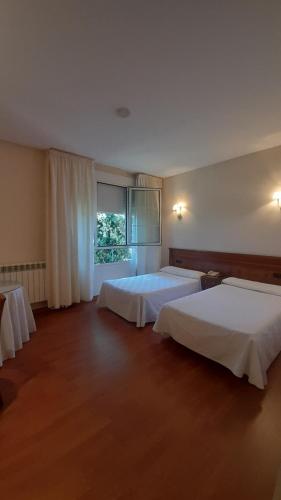 Hotel Las Moreras في ليون: غرفة فندقية بسريرين ونافذة