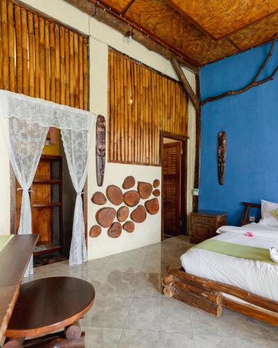 a bedroom with a bed and a table in a room at Gading Tree House in Nusa Penida