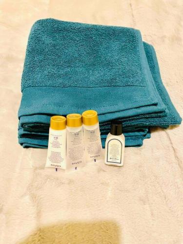 three bottles of soap and a towel on a bed at Spacious 2 Bedroom Apt Newcastle Upon Tyne in Elswick