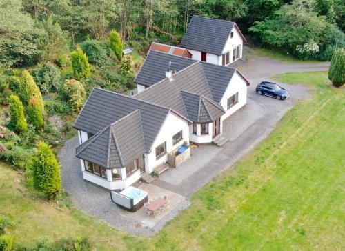 an aerial view of a house with a car in the driveway at Wildwood Cottage with Hot Tub in Glencoe