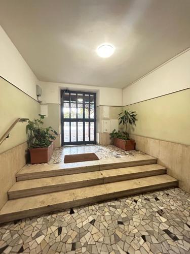 a room with stairs and potted plants and a window at Stella Polare Sensorial Home in Lido di Ostia