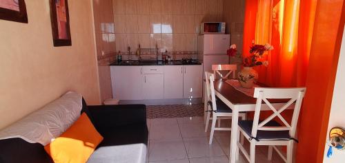 una pequeña cocina con mesa y una pequeña cocina con comedor. en Casa Leyla, en Vilaflor