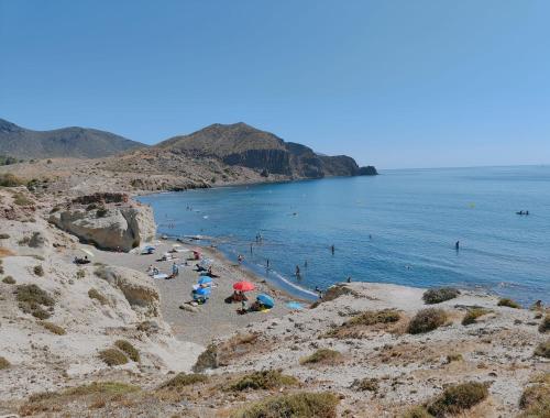 un grupo de personas en una playa cerca del océano en Pita 2, en La Isleta del Moro