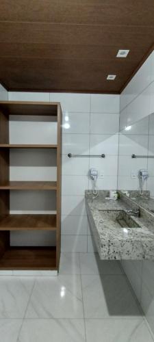 baño con lavabo y 2 espejos en RESORT CHALÉ DA PRATA, en Curvelo