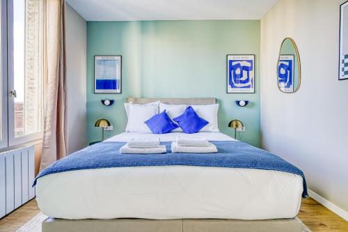 une chambre avec un grand lit aux murs bleus dans l'établissement Appartement proche Porte d'Italie, à Ivry-sur-Seine