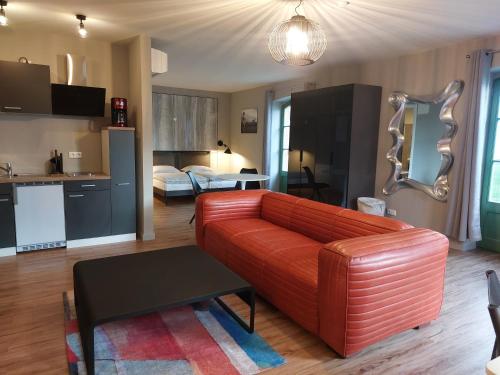 ein Wohnzimmer mit einem roten Sofa und einer Küche in der Unterkunft SEA YOU in Klink