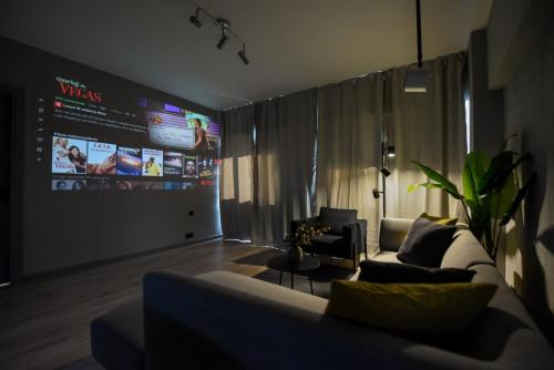 a living room with a couch and a large screen at Luxury Apartment near Radisson Hotel - Wall Projector & Modern Design in Bucharest