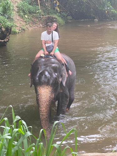 a man and woman riding on the back of an elephant in the water at Airport Faith Hotel in Katunayake