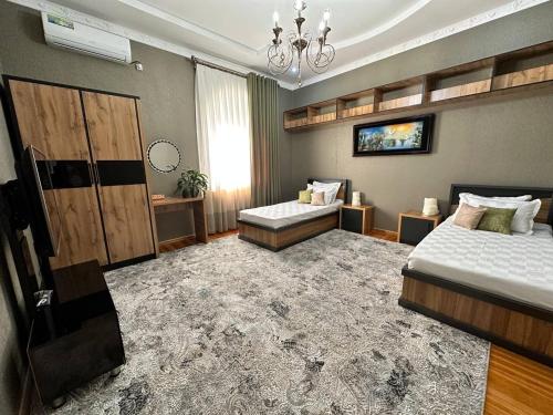 um quarto com 2 camas e um lustre em VILLA ANOR em Yakkasaray