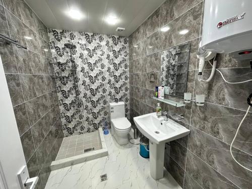 a bathroom with a toilet and a sink at VILLA ANOR in Yakkasaray
