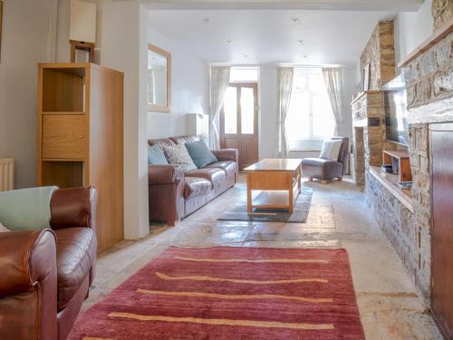 a living room with a couch and a fireplace at Quarry Cottage Courtyard Garden Pass the Keys in Cirencester