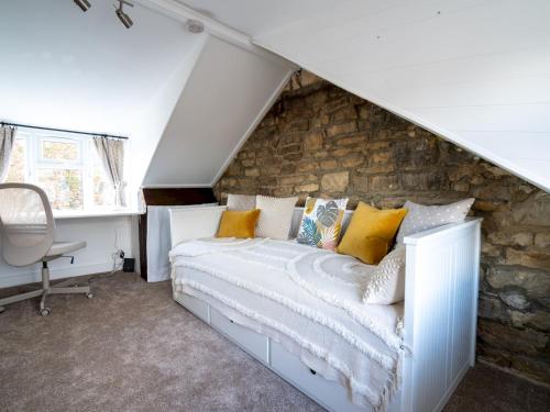 a bedroom with a bed and a stone wall at Pass the Keys Quarry Cottage Courtyard Garden in Cirencester