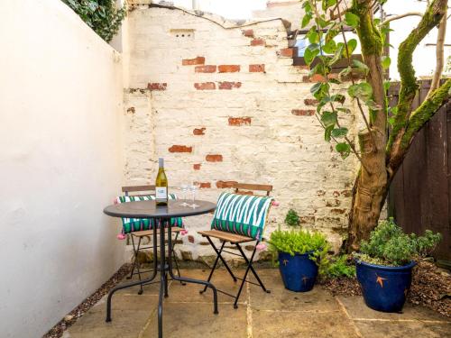 a small patio with a table and two chairs at Quarry Cottage Courtyard Garden Pass the Keys in Cirencester