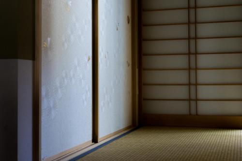 an empty room with a sliding glass door at Guesthouse ZenNichi in Kyoto