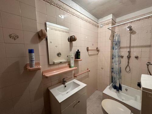 La salle de bains est pourvue d'un lavabo, de toilettes et d'un miroir. dans l'établissement Quarto privativo perto Centro Porto, à Porto