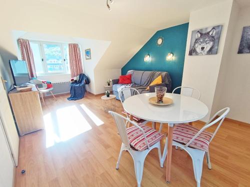 un salon avec une table et des chaises blanches dans l'établissement L'Esquiros, studio, centre Luchon, casier à skis, wifi, ascenseur, 3 personnes, à Luchon