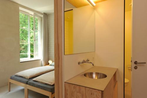 uma casa de banho com um lavatório e um espelho em Basel Youth Hostel em Basileia
