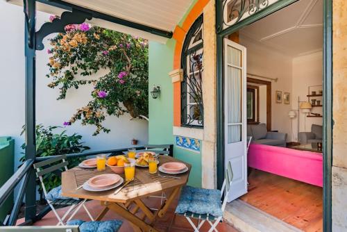 een patio met een houten tafel met sinaasappels erop bij Estoril Historical Villa by the Sea in Estoril