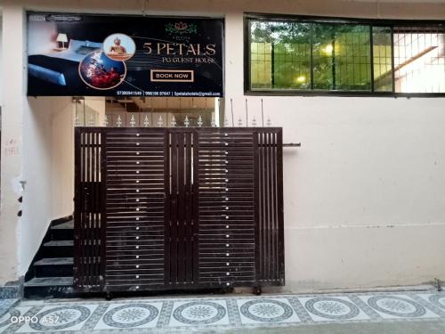 une porte devant un bâtiment avec un panneau dans l'établissement 5 PETALS, à Varanasi