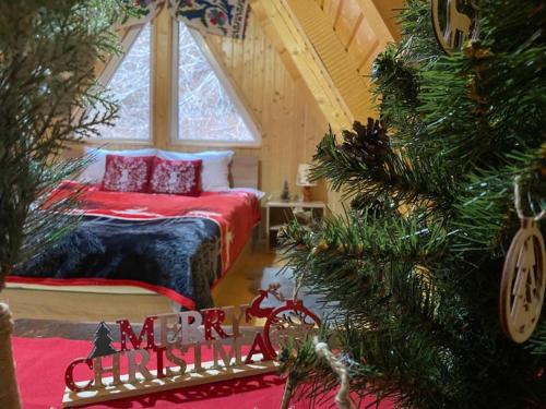a bedroom with a christmas tree in front of a bed at Cabanutze Satic in Rucăr