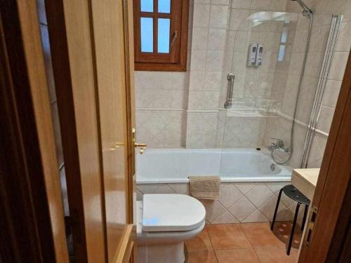 a bathroom with a toilet and a bath tub at Ático acogedor centro de Canillo in Canillo