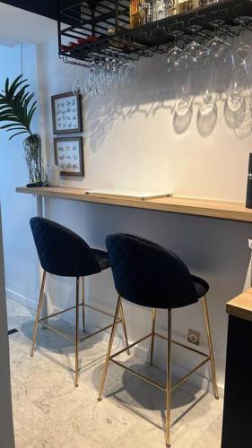 - un bar avec deux chaises et un comptoir avec des verres dans l'établissement Cosy renovated 1-bedroom Etoile, à Paris