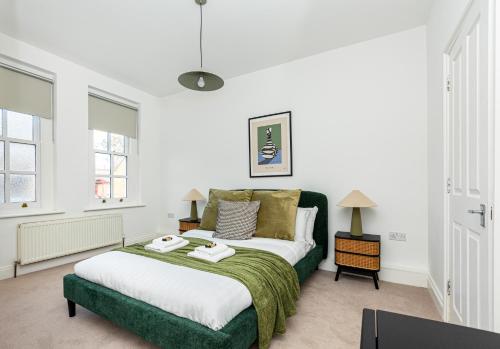 sypialnia z dużym łóżkiem i zielonym kocem w obiekcie Spacious 4BR 3-Storey Townhouse in Lively Deptford w Londynie