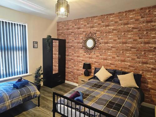 um quarto com uma parede de tijolos e uma cama em Fife House - Welcome Short Stays em Derby