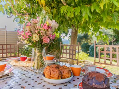 une table avec de la nourriture et un vase de fleurs dans l'établissement Holiday Home Lumière by Interhome, à Vinsobres