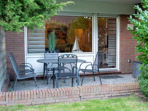 um pátio com uma mesa e cadeiras em frente a uma casa em Apartment Niki by Interhome em Norddeich