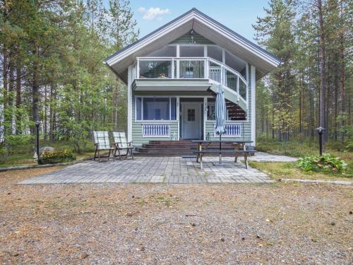 ein Haus mit einer Veranda und 2 Stühlen auf einer Terrasse in der Unterkunft Holiday Home Rajala by Interhome in Neuvosenniemi