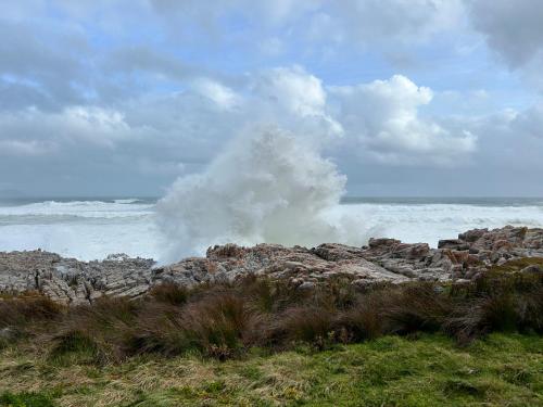 a wave crashing on the rocks near the ocean at Sixteen Guesthouse on Main in Hermanus