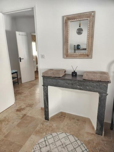 een tafel in een kamer met een spiegel en een tapijt bij Le Beffroi de Gaston in Aix-en-Provence