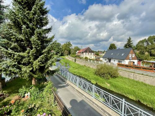 a river with a tree next to a fence at Holiday Home Sissi by Interhome in Großschönau
