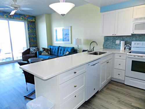 eine Küche mit einem Waschbecken und ein Wohnzimmer in der Unterkunft 1 BR Direct Oceanfront Condo Wyndham Ocean Walk Resort - Daytona Funland 703 in Daytona Beach