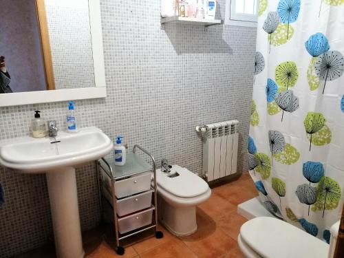 ein Badezimmer mit einem Waschbecken, einem WC und einem Duschvorhang in der Unterkunft Shivanda, Habitaciones en Centro de Bienestar en la Naturaleza in Pioz