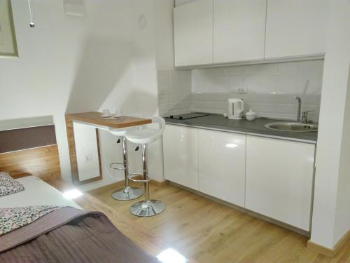 uma pequena cozinha branca com um lavatório e um banco em Hedonic Studio em Belgrado