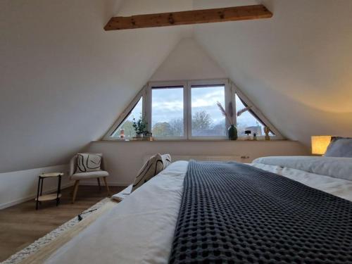 sypialnia na poddaszu z łóżkiem i oknem w obiekcie Voll ausgestattetes 2 Zimmer Apartment Sanssouci w mieście Osnabrück