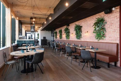 restauracja ze stołami i krzesłami oraz ceglaną ścianą w obiekcie Quai Central w mieście Tourcoing