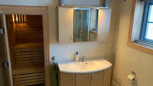 uma casa de banho com um lavatório e um espelho em Panorama Logde Stryn, with Jacuzzi, Sauna and Spectacular Views! em Stryn