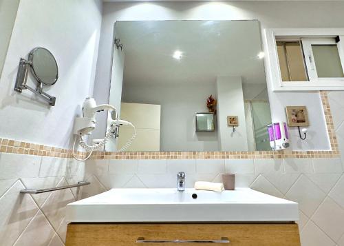 a bathroom with a sink and a large mirror at Modern Renovated One Bed Apartment in Edificio Apolo Marbella Center in Marbella