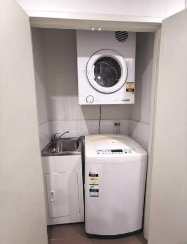 a small bathroom with a washing machine and a washer at Doraemon : loving childhood memories. in Sydney