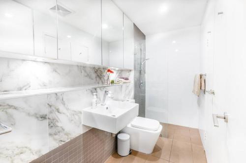 a white bathroom with a sink and a toilet at Doraemon : loving childhood memories. in Sydney