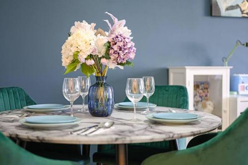a table with plates and a vase of flowers on it at Doraemon : loving childhood memories. in Sydney