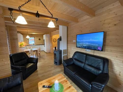 un soggiorno con mobili in pelle e TV a schermo piatto di Holiday Home Chalet Sven by Interhome a Spiegelau